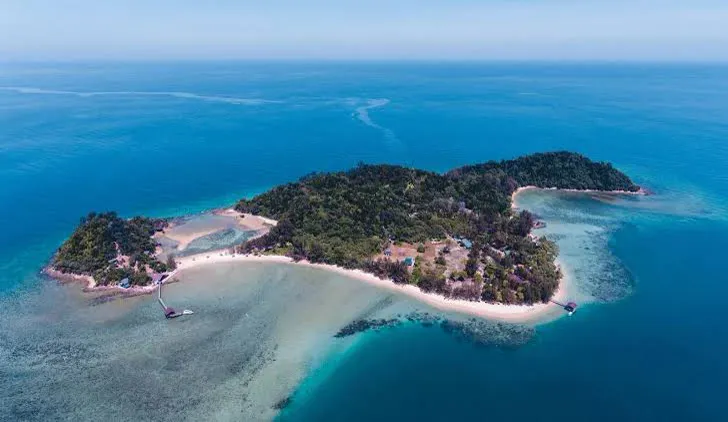 Aerial view of a forested island edged by sea near Kota Kinabalu, Borneo