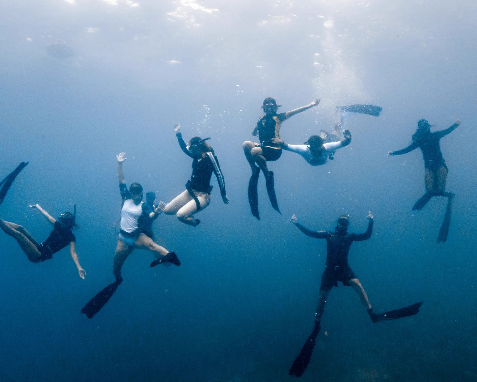 Freedivers in formation in the open water off Bira